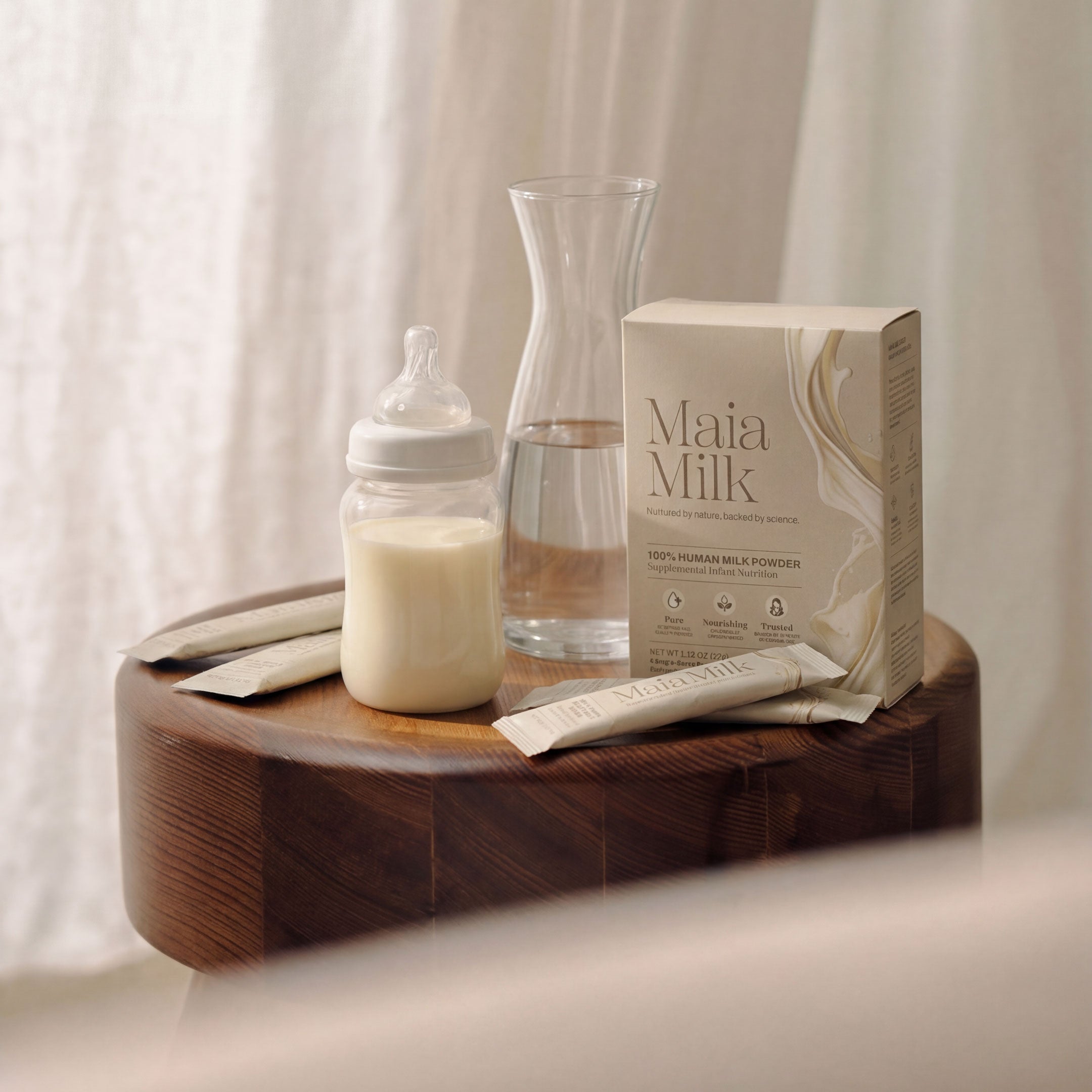 Maia Milk packaging with a bottle and carafe on a wooden tray against a neutral background